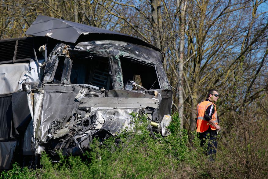 A railway worker stands near a high-speed train (TGV) after he crashed into a truck carrying military equipment in Bully-les-Mines, northern France, Tuesday, April 7, 2026. (AP Photo/Jean-Francois Badias)