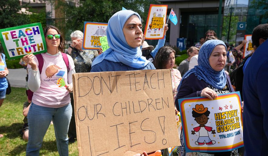 Aasya Peera of Pflugerville holds a sign reading "Don't teach our children lies!" during a rally on the Capitol Mall outside the Barbara Jordan State Office Building, where the State Board of Education meets, Tuesday, April 7, 2026, in Austin, Texas. (Jay Janner/Austin American-Statesman via AP)