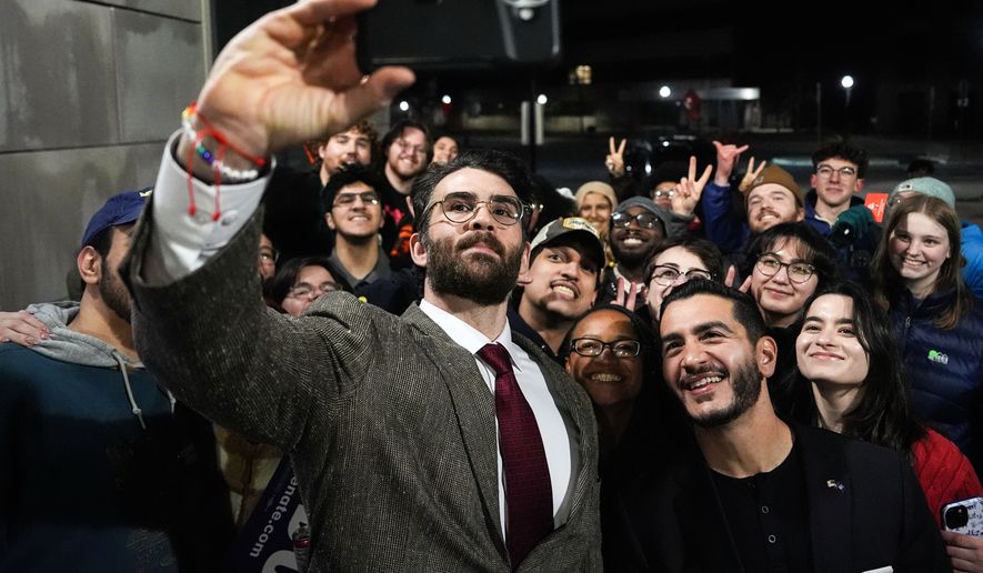 Streamer Hasan Piker, left, and Abdul El-Sayed, a progressive candidate in the Democratic primary for U.S. Senate in Michigan, center right, take a selfie with young fans following a campaign event, Tuesday, April 7, 2026, at the University of Michigan in Ann Arbor, Mich. (AP Photo/Julia Demaree Nikhinson)