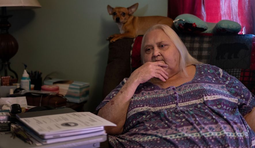 Rebecca Michalski pauses as she talks about electric bills she cannot pay while sitting next to her Chihuahua, Enos, at her home in Rainelle, W.Va., Saturday, March 21, 2026. (AP Photo/Carolyn Kaster)