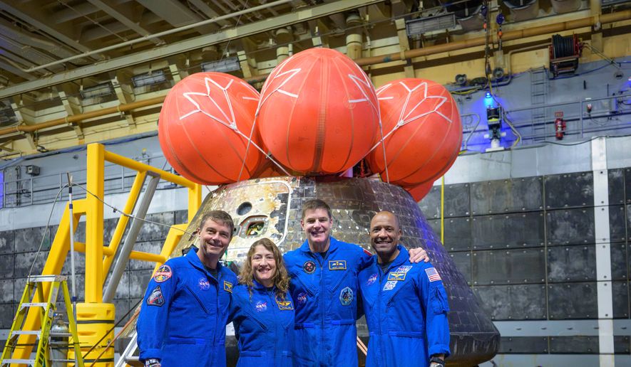 In this photo provided by NASA, from left, NASA astronauts Reid Wiseman, commander; Christina Koch, mission specialist; CSA (Canadian Space Agency) astronaut Jeremy Hansen, mission specialist; and NASA astronaut Victor Glover, Artemis II pilot, right, pose for a group photo after viewing the Orion spacecraft in the well deck of USS John P. Murtha, Saturday, April 11, 2026, in the Pacific Ocean off the coast of California. (Bill Ingalls/NASA via AP)