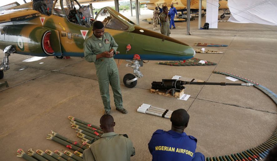 FILE - In this photo taken on April 22, 2017, Nigerian Air Force officers display ammunition next to a fighter jet during an event in Makurdi, Nigeria. (AP Photo/ Sunday Alamba, file)