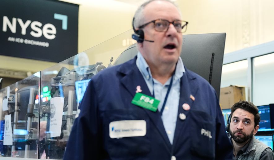 People work on the floor at the New York Stock Exchange in New York, Monday, April 13, 2026. (AP Photo/Seth Wenig)