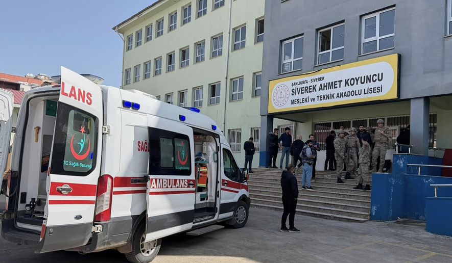 Turkish security forces and emergency staff stand at the courtyard of a high school where an assailant opened fire, in Siverek, south east Turkey, Tuesday, April 14, 2026, (Mevlut Bayraktar/IHA via AP)