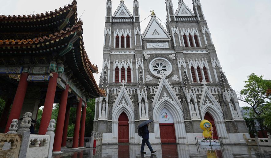 A man walks out from a pavilion near the Xishiku Catholic Church during a rainy day in Beijing, May 9, 2025. (AP Photo/Andy Wong, File)