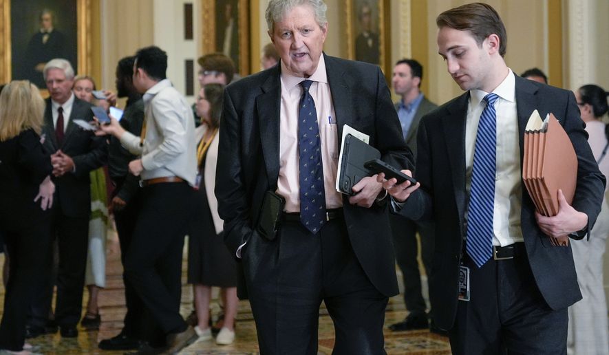 Sen. John Kennedy, R-La., center, speaks with a reporter, Tuesday, April 14, 2026, in Washington. (AP Photo/Mariam Zuhaib)