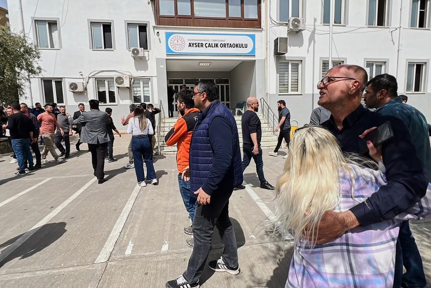 People stand at the courtyard of a secondary school where an assailant opened fire, in Kahramanmaras, Turkey, Wednesday, April 15, 2026, (IHA via AP)
