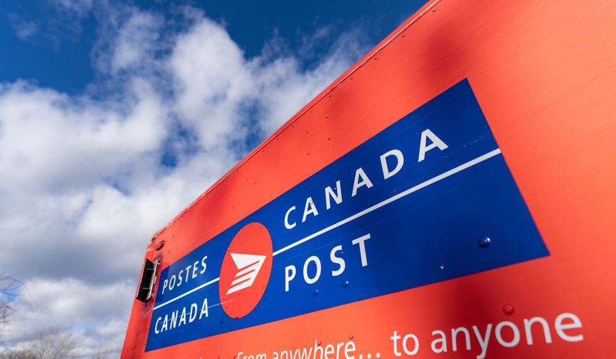 A Canada Post mail truck is seen parked in their distribution center, in Montreal, Nov. 27, 2024. (Christinne Muschi/The Canadian Press via AP, File)