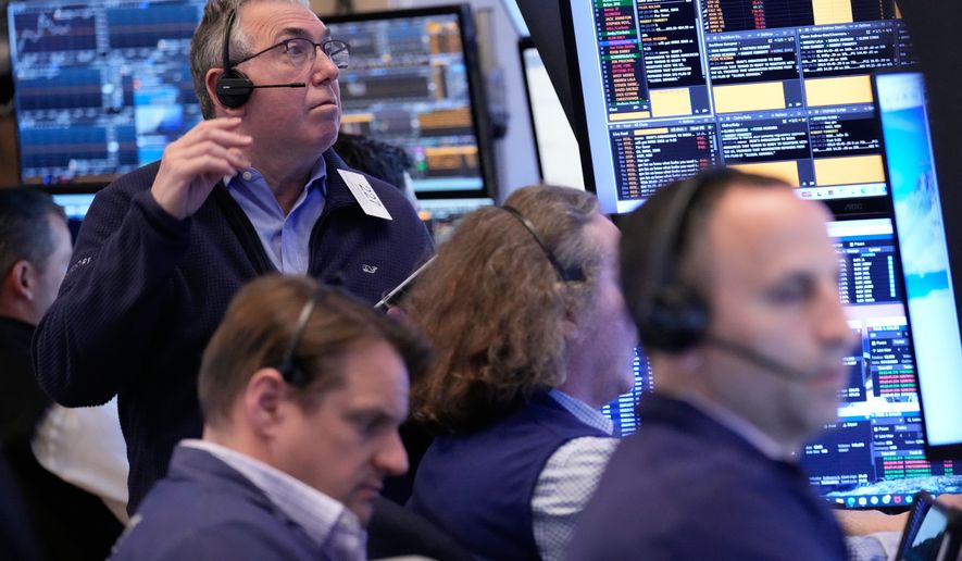 John Bishop, left, and others work on the floor at the New York Stock Exchange in New York, Monday, April 13, 2026. (AP Photo/Seth Wenig)