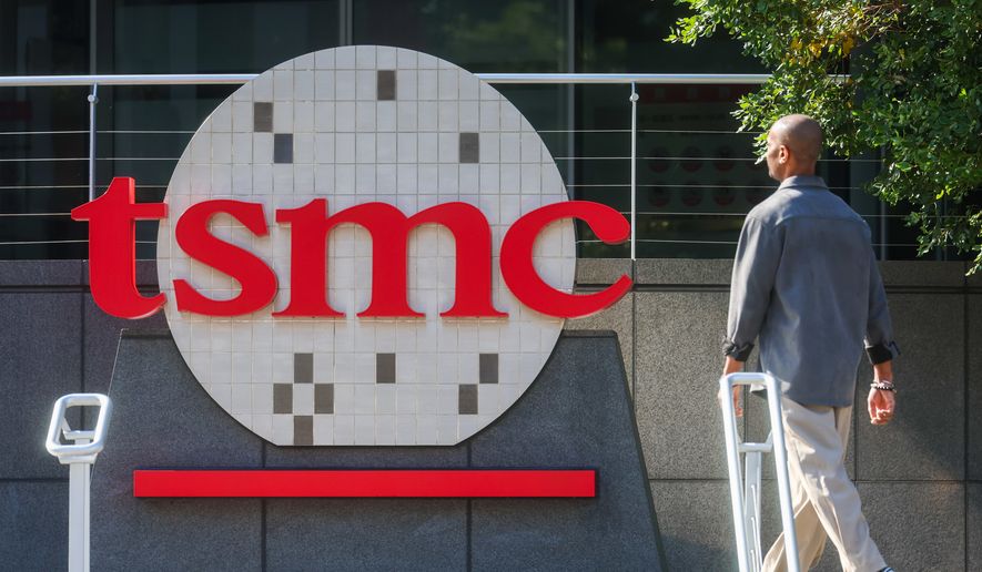 FILE -A worker walks past the logo of TSMC or Taiwan Semiconductor Manufacturing Corp., a Taiwanese multinational semiconductor contract manufacturing and design company, in Hsinchu, Taiwan, on Thursday, Jan. 29, 2026. (AP Photo/Daniel Ceng, File)
