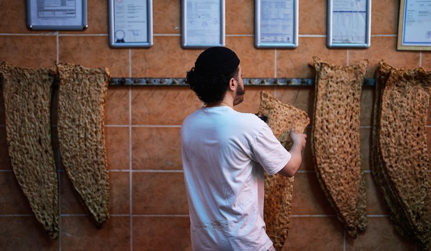 A baker hangs bread in an Iranian bakery in Istanbul on Tuesday, April 14, 2026. (AP Photo/Khalil Hamra)