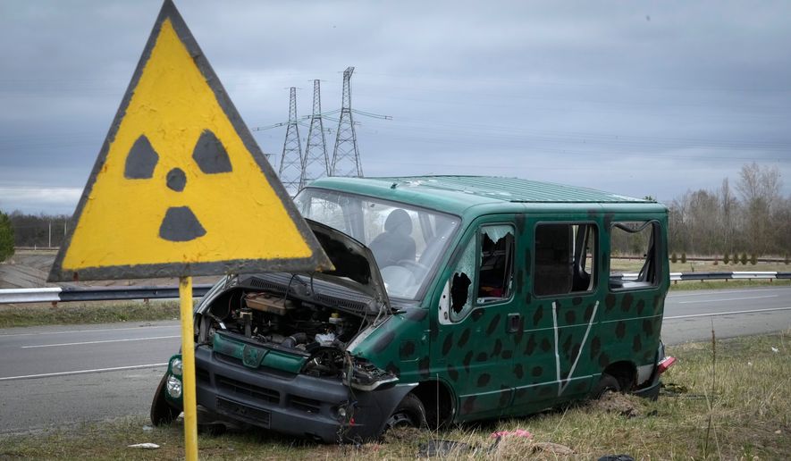 FILE - A radiation sign stands near the remains of a vehicle belonging to the Russian military near the Chernobyl nuclear power plant in Chernobyl, Ukraine, April 16, 2022. (AP Photo/Efrem Lukatsky, File)