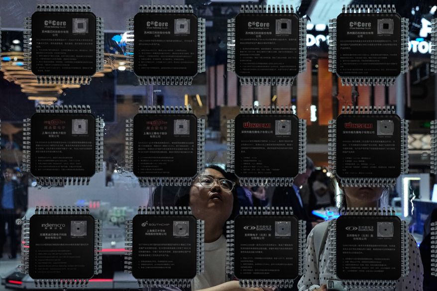 A woman looks at various Chinese-made chips for the automotive market showcased at the Auto China 2026 in Beijing on Saturday, April 25, 2026. (AP Photo/Andy Wong) **FILE**