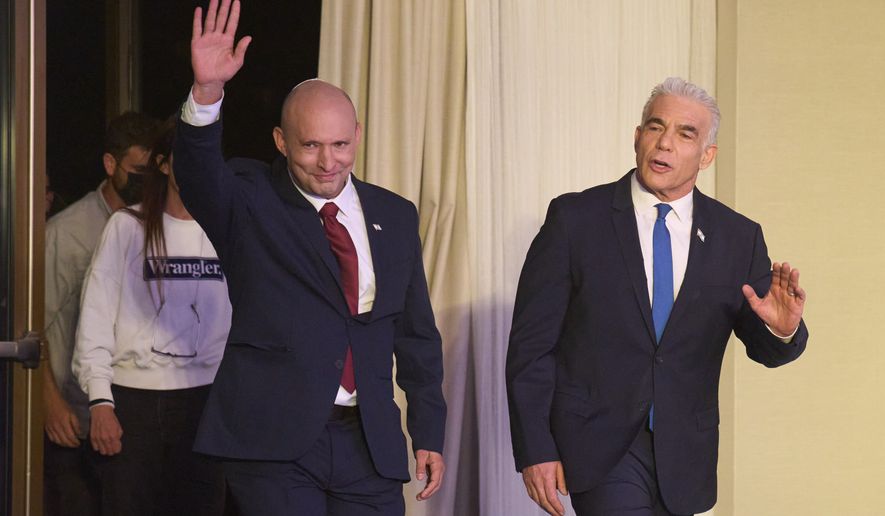 Former Israeli prime ministers Naftali Bennett, left, and Yair Lapid arrive to a joint press conference announcing that their parties will run together in the upcoming elections, in Herzliya, Israel, Sunday, April 26, 2026. (AP Photo/Ariel Schalit)