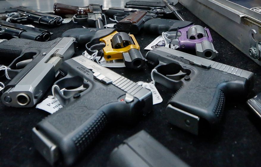 In this Jan. 26, 2013, file photo, handguns are displayed on a vendor's table at an annual gun show in Albany, N.Y. (AP Photo/Philip Kamrass, File)