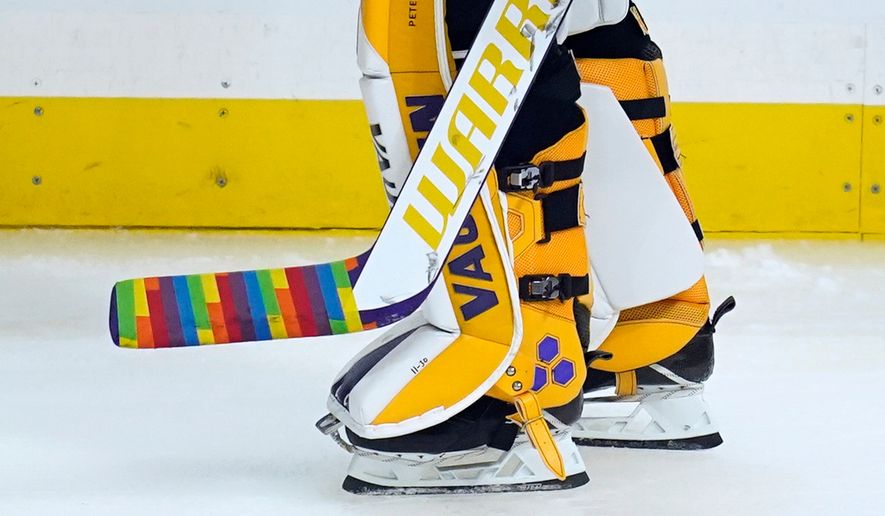 Los Angeles Kings goaltender Calvin Petersen (40) holds a stick wrapped in rainbow tape for Pride night while warming up before an NHL hockey game April 26, 2021, in Los Angeles. (AP Photo/Ashley Landis, File)