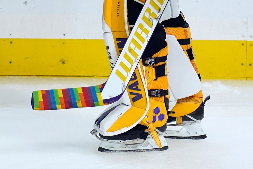 Los Angeles Kings goaltender Calvin Petersen (40) holds a stick wrapped in rainbow tape for Pride night while warming up before an NHL hockey game April 26, 2021, in Los Angeles. (AP Photo/Ashley Landis, File)