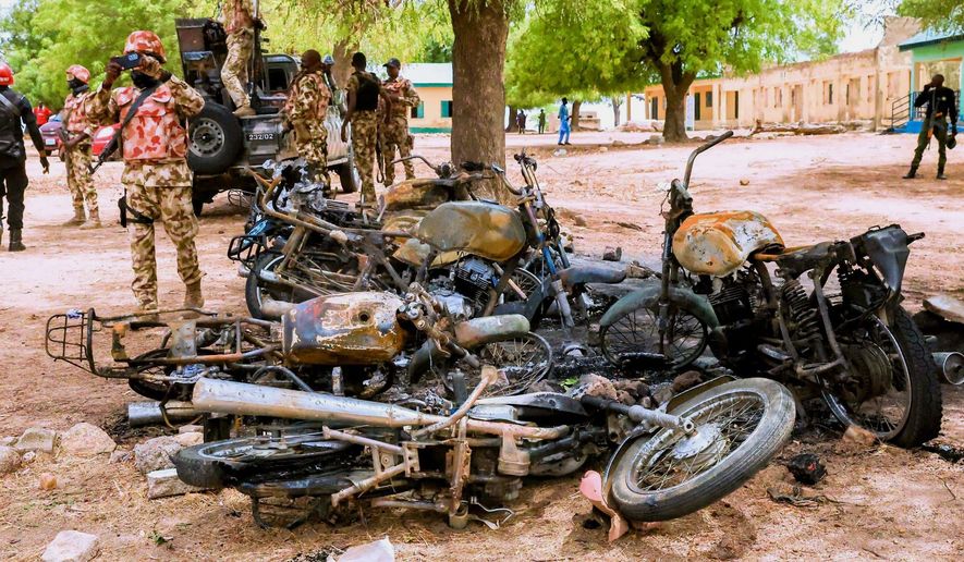 In this photo, released by Adamawa State Government House, a soldier takes photos of burned motorbikes in Guyaku, northeastern Nigeria, Monday, April 27, 2026, following an attack by Militants with the Islamic State group on Sunday. (Adamawa state government house via AP)
