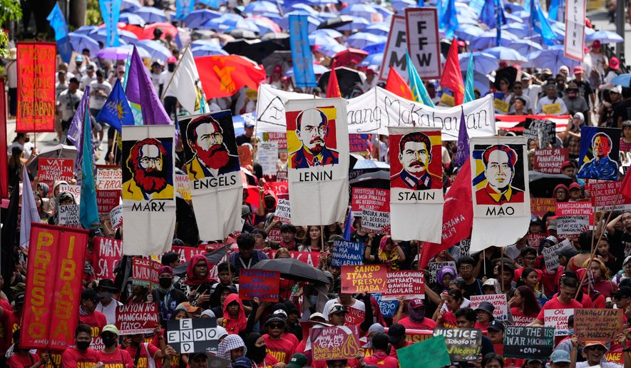 Protesters hold posters of communist figures as they march towards the Malacanang presidential palace during a May Day rally in Manila, Philippines on Friday, May 1, 2026. (AP Photo/Aaron Favila)