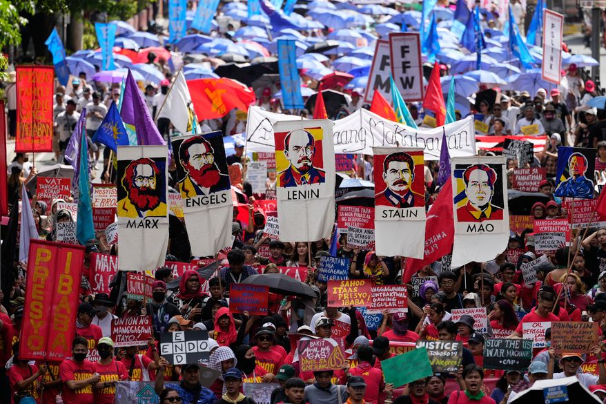 Protesters hold posters of communist figures as they march towards the Malacanang presidential palace during a May Day rally in Manila, Philippines on Friday, May 1, 2026. (AP Photo/Aaron Favila)
