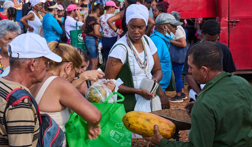 People line up to buy papaya at a weekly food fair in Alamar, Havana province, Cuba, Saturday, May 2, 2026. (AP Photo/Ramon Espinosa)