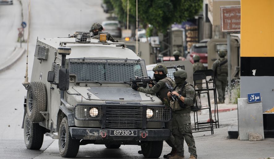 Israeli soldiers take positions during clashes with Palestinians in the West Bank city of Nablus, Sunday, May 3, 2026. (AP Photo/Majdi Mohammed)
