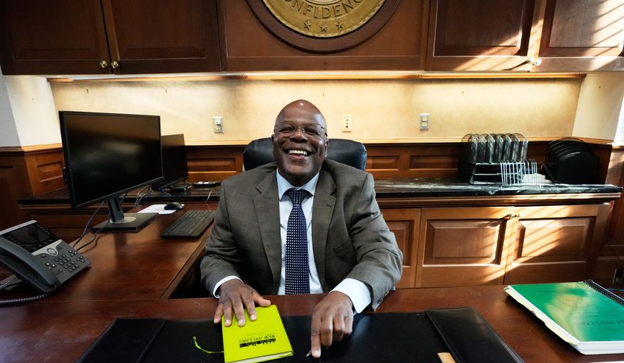 Calvin Duncan, left, an exoneree who was elected Orleans Parish clerk of criminal court, gets behind his desk on the first day of his term, Monday, May 4, 2026, in New Orleans. (AP Photo/Gerald Herbert)