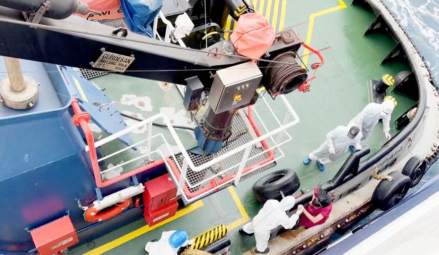 Health workers get off the Dutch-flagged MV Hondius, a cruise ship carrying nearly 150 people as it remains off Cape Verde on Monday, May 4, 2026 after three passengers died and several others fell seriously ill in a suspected hantavirus outbreak. (Qasem Elhato via AP)