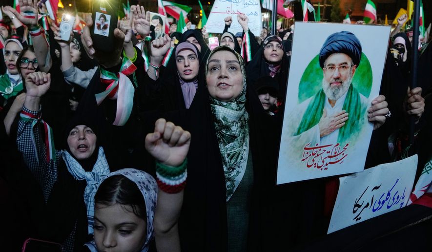 Pro-government demonstrators chant slogans as one of them holds a poster of the Iranian Supreme Leader Ayatollah Mojtaba Khamenei during their gathering at Enqelab-e-Eslami, or Islamic Revolution, square in Tehran, Iran, Monday, May 4, 2026. (AP Photo/Vahid Salemi)