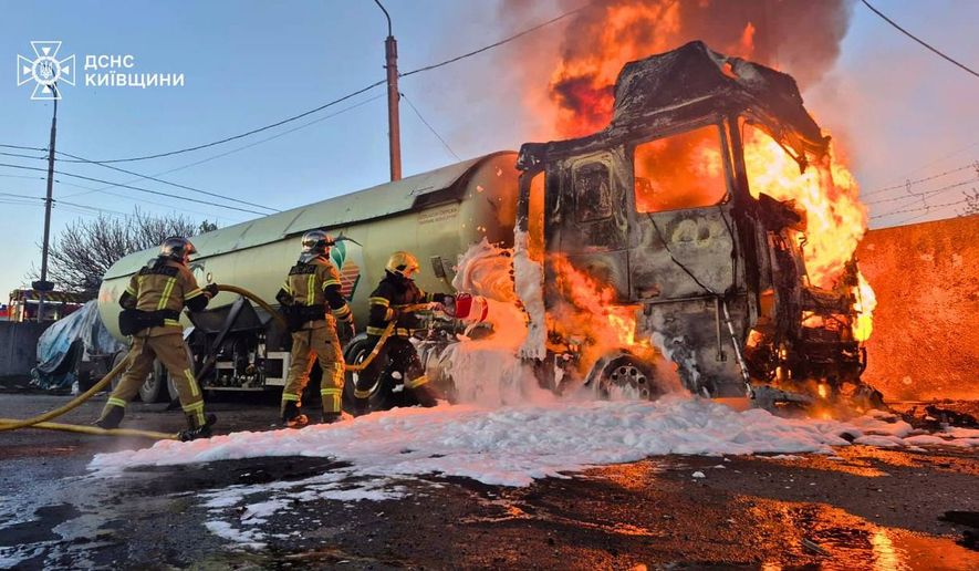In this photo, provided by the Ukrainian Emergency Service, emergency services personnel work to extinguish a fire a vehicle following a Russian drone attack in Kyiv region, Ukraine, Tuesday, May 5, 2026. (Ukrainian Emergency Service via AP)