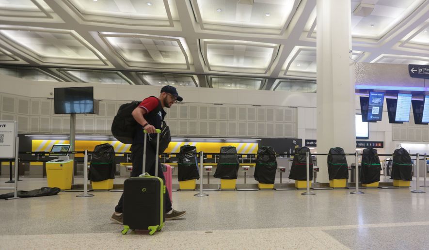 A traveler walks past covered Spirit Airlines kiosks, Saturday, May 2, 2026, at George Bush Intercontinental Airport, in Houston. (AP Photo/Lekan Oyekanmi)
