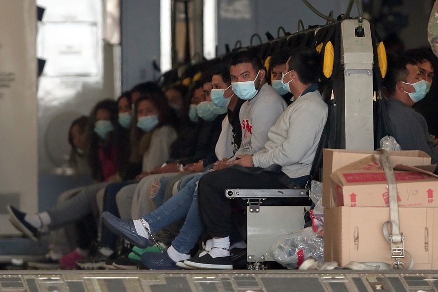 Migrants wearing face masks and shackles on their hands and feet sit on a military aircraft at Fort Bliss in El Paso, Texas, Jan. 30, 2025, awaiting their deportation to Guatemala. (AP Photo/Christian Chavez, File)