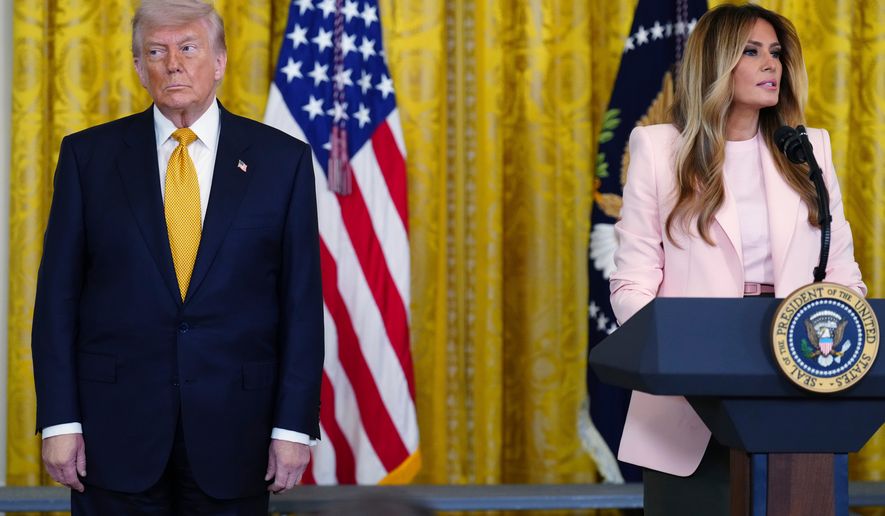 President Donald Trump listens as first lady Melania Trump speaks at a Mother's Day event for members of the military, Wednesday, May 6, 2026, in the East Room of the White House, in Washington. (AP Photo/Jacquelyn Martin)