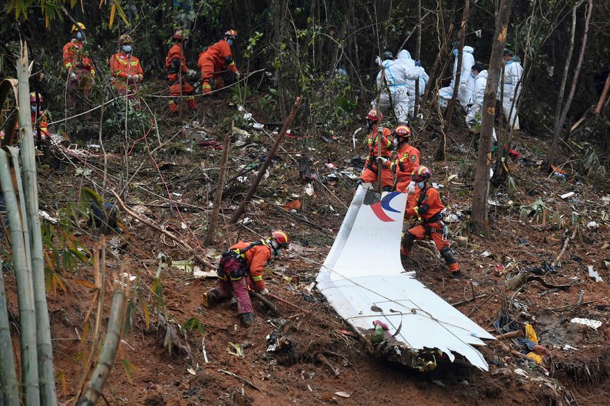 In this photo released by Xinhua News Agency, search and rescue workers search through debris at the China Eastern flight crash site in Tengxian County in southern China's Guangxi Zhuang Autonomous Region on March 24, 2022. (Lu Boan/Xinhua via AP, File)