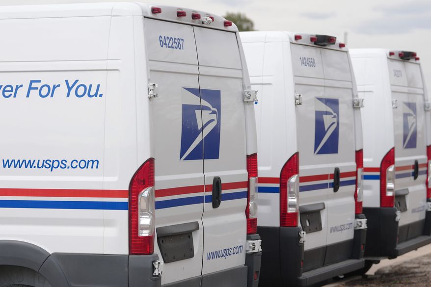 The United States Postal Service logo is shown on delivery vans parked outside the main post office in east Denver on March 23, 2026. (AP Photo/David Zalubowski) **FILE**
