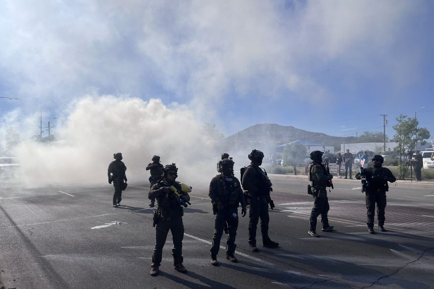 Federal agents block Grande Avenue on Friday, Dec. 5, 2025, in Tucson, Ariz. (John Washington/Arizona Luminaria via AP)