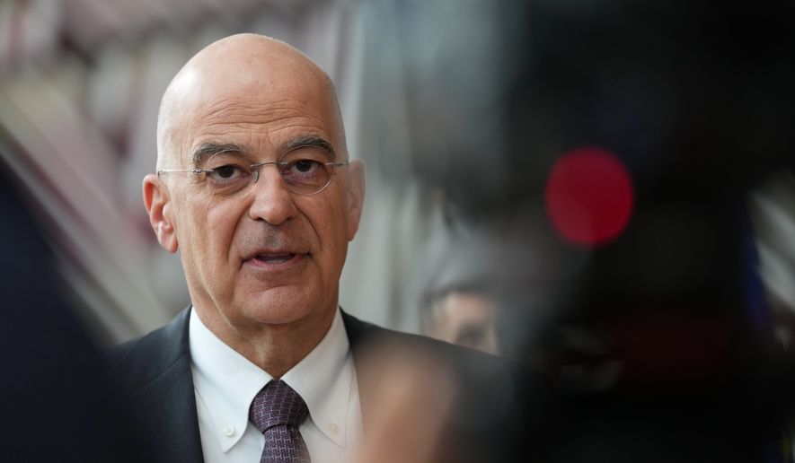 Greece's Defense Minister Nikolaos Dendias speaks with the media as he arrives for a meeting of EU defense ministers at the European Council building in Brussels, Tuesday, May 12, 2026. (AP Photo/Virginia Mayo)