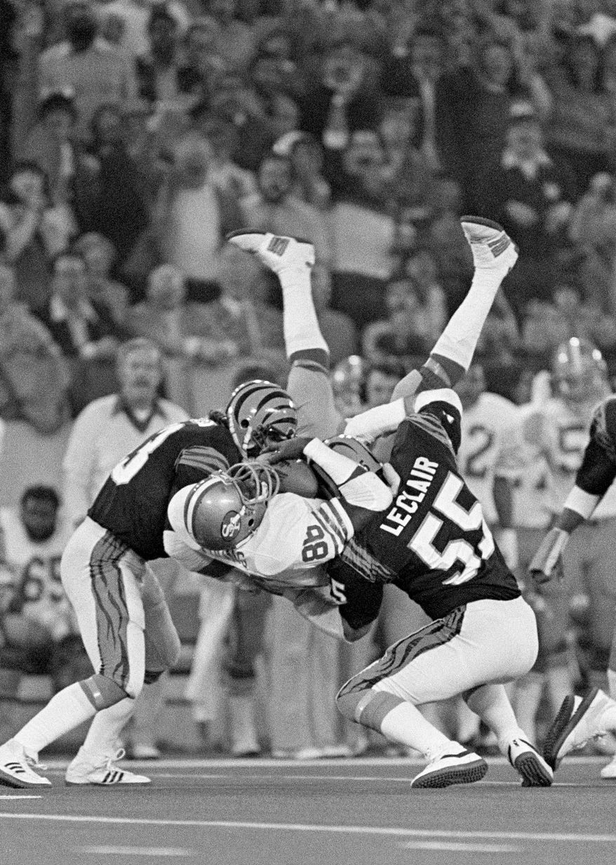 San Francisco 49ers tight end Charle Young (86) holds on to a Joe Montana pass as he is tackled by Cincinnati Bengals Jim LeClair and Bo Harris in the first quarter of the NFL Super Bowl 16 football game on Jan. 24, 1982, in Pontiac, Mich. (AP Photo/Rusty Kennedy, File)