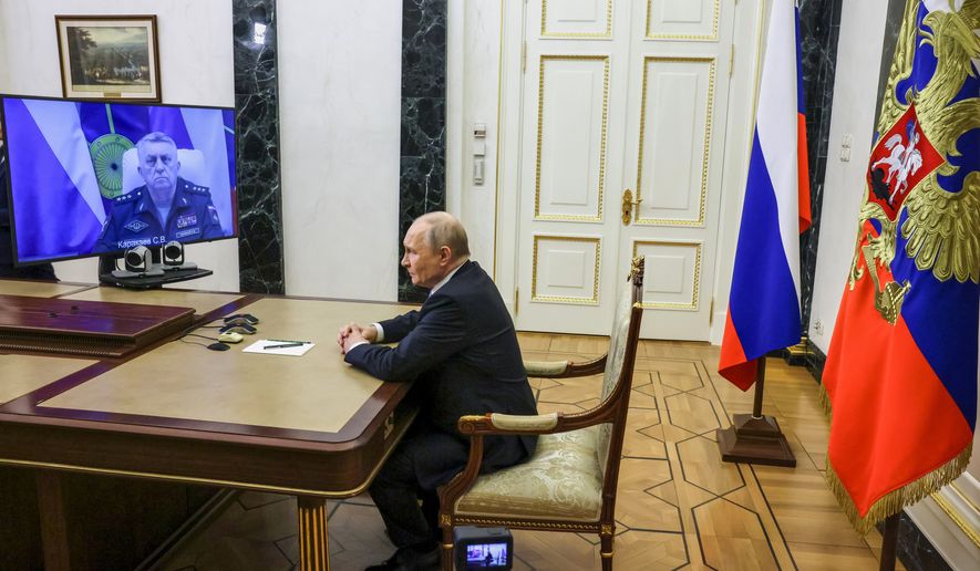 Russian Strategic Missile Forces chief, Col. Gen. Sergei Karakayev, left on the screen, reports to President Vladimir Putin on a successful test launch of the Sarmat intercontinental ballistic missile at the Kremlin in Moscow, Tuesday, May 12, 2026. (Mikhail Metzel/Sputnik, Kremlin Pool Photo via AP)