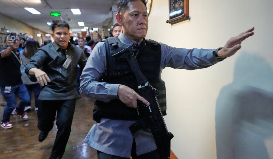 Senate security run after gunfire was heard along a hallway at the Philippine Senate in Pasay, Philippines, Wednesday, May 13, 2026. (AP Photo/Aaron Favila)