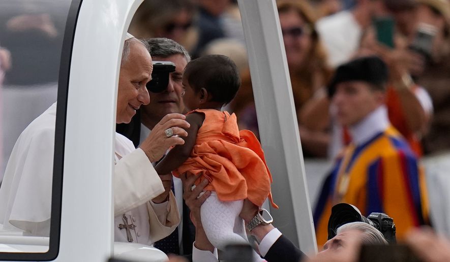 Pope Leo XIV blesses a little girl as he arrives for his weekly general audience in St. Peter's Square, at the Vatican, Wednesday, May 13, 2026. (AP Photo/Alessandra Tarantino)