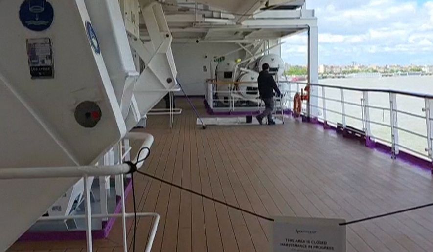 A man walks on a deck of the British cruise ship the Ambition after 1,700 passengers and crew were ordered to remain on board after an outbreak of gastrointestinal illness, in the port of Bordeaux, France, Wednesday, May 13, 2026. (Kevin Starrs via AP)
