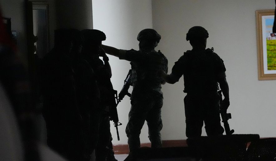 Philippine troopers exchange fire along a hallway at the Philippine Senate in Pasay, Philippines, on Wednesday May 13, 2026. (AP Photo/Aaron Favila)