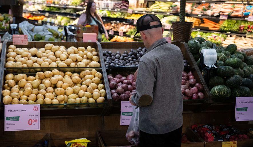 Customers shop in the produce section of a grocery store on Monday, May 11, 2026, in Portland, Ore. (AP Photo/Jenny Kane)