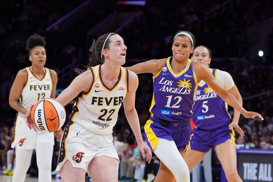 Indiana Fever guard Caitlin Clark (22) drives past Los Angeles Sparks guard-forward Rae Burrell (12) during the first half of a WNBA basketball game Wednesday, May 13, 2026, in Los Angeles. (AP Photo/Jae C. Hong)