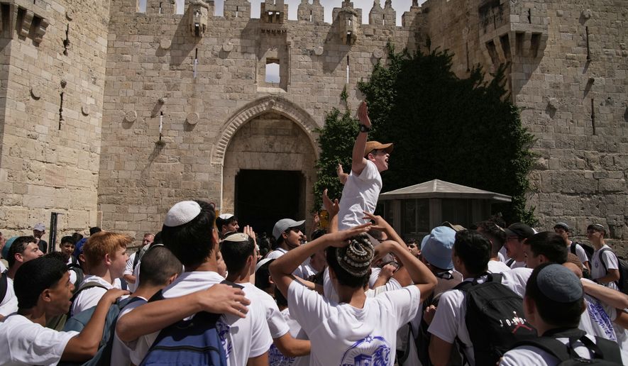 Israeli youth celebrate in Damascus Gate ahead of a march marking Jerusalem Day, an Israeli holiday celebrating the capture of east Jerusalem in the 1967 Mideast war, in Jerusalem's Old City, Thursday, May 14, 2026.(AP Photo/Leo Correa)