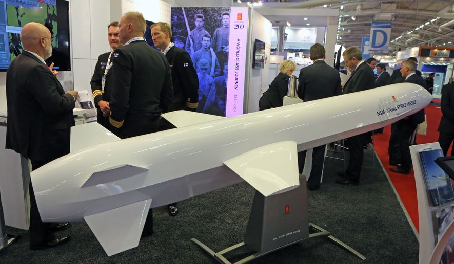 Visitors are gathered next to a display of an NSM Naval Strike Missile made by Norwegian company Kongsberg, presented at the Euronaval show, in Le Bourget, North of Paris, France, Wednesday Oct. 29, 2014. (AP Photo/Remy de la Mauviniere)