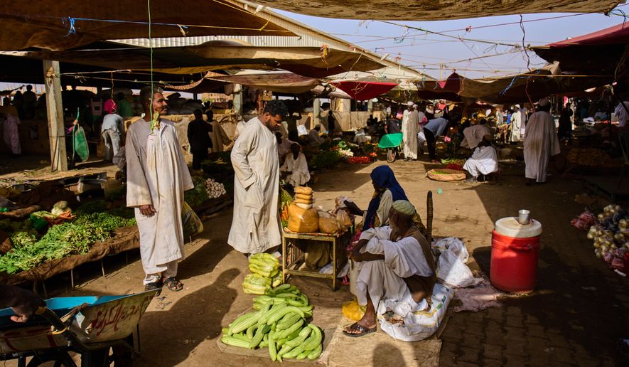 Customers buy vegetables at a market in Omdurman, on the outskirts of Khartoum, Sudan, Sunday, April 26, 2026. (AP Photo/Bernat Armangue)