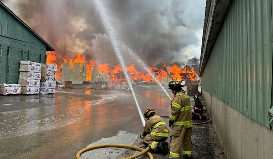 This photo provided by the Maine Department of Public Safety shows Firefighters try to extinguish flames from a large fire at Robbins Lumber in Searsmont, Maine on Friday, May 15, 2026 (Maine Department of Public Safety via AP)