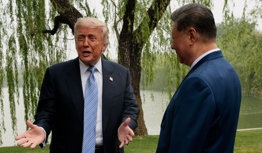 U.S. President Donald Trump, left, speaks as he is greeted by Chinese President Xi Jinping at Zhongnanhai Garden in Beijing, China, Friday, May 15, 2026. (Evan Vucci/Pool Photo via AP)
